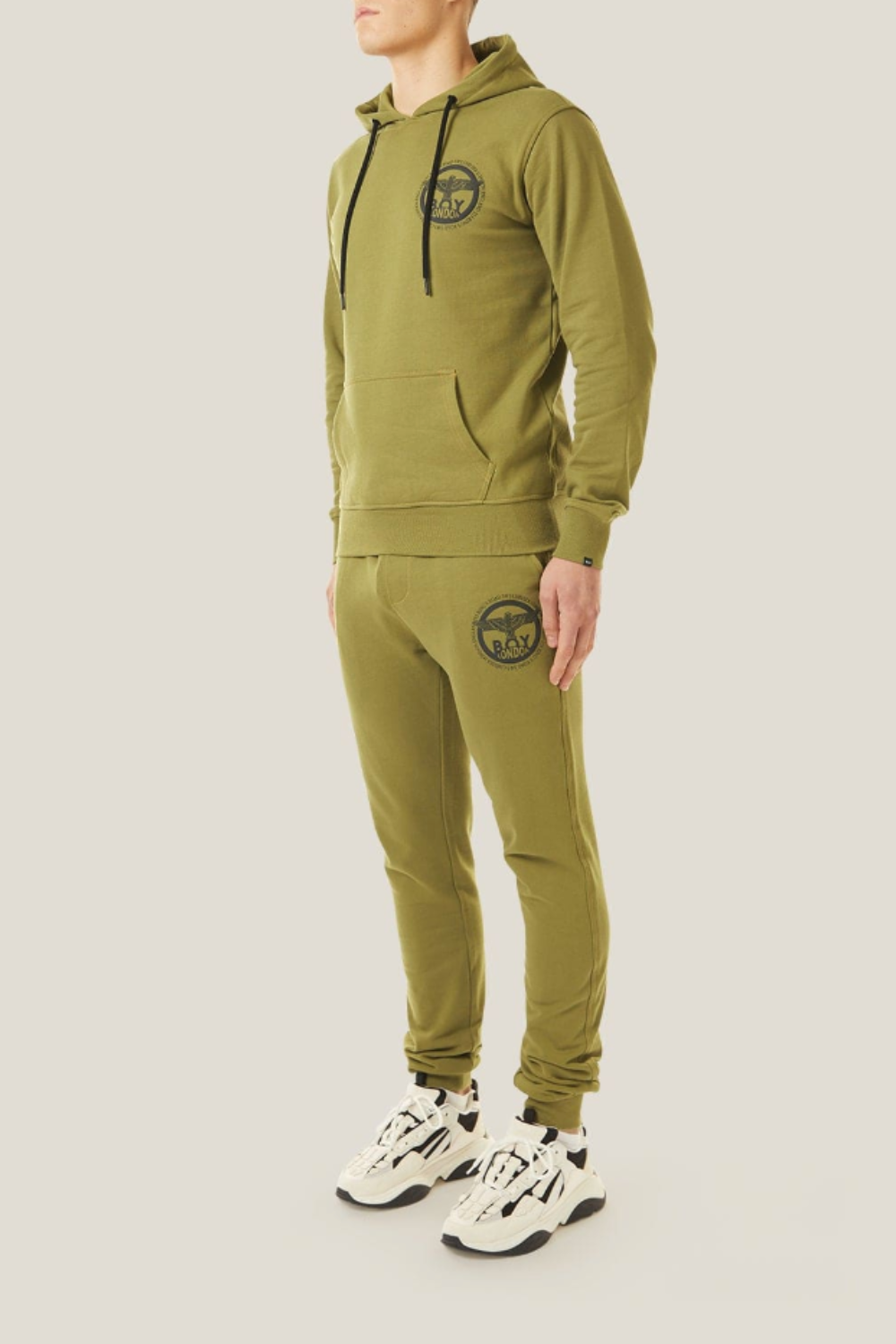 Model wearing a green BOY London tracksuit with a logo on a light gray background