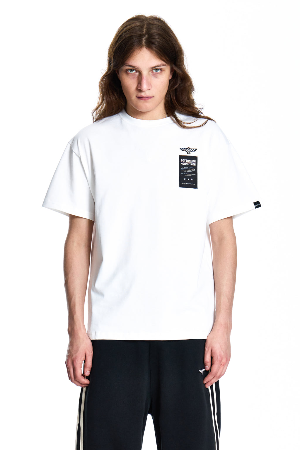Person wearing a white Boy London t-shirt with a logo on a white background