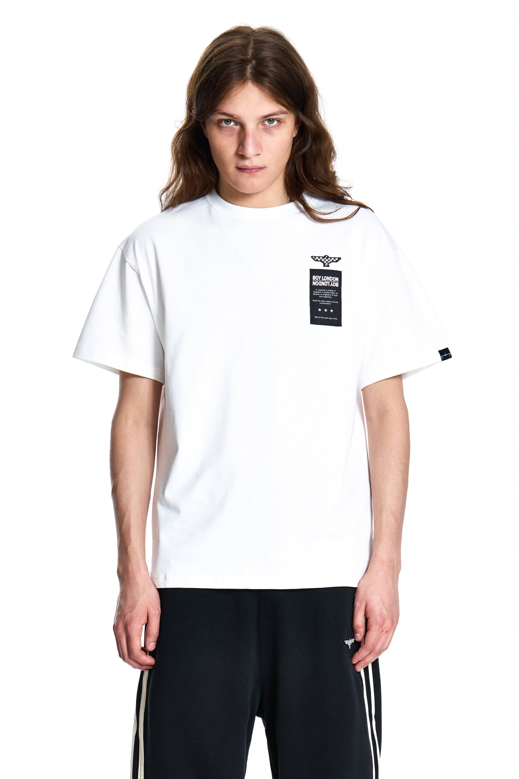 Person wearing a white Boy London t-shirt with a logo on a white background